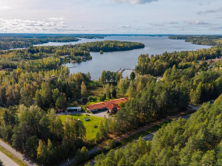Kotirauha lastenkodista ja ympäröivästä järvestä kuva lintuperspektiivistä korkealta.